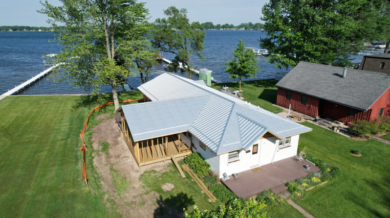white one story house with lightblue metal roofing bourbon in